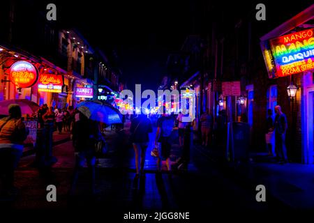 Bourboun Street di New Orleans (Louisiana) di notte, che mostra i riflessi delle luci al neon sulla strada Foto Stock