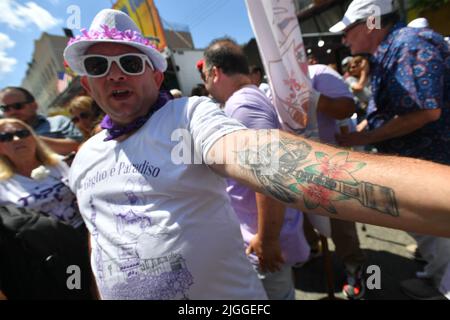 Un uomo mostra il suo tatuaggio di un Giglio durante l'annuale festa della Madonna del Monte Carmelo il 10 luglio 2022 nel quartiere Williamsburg di Brooklyn, Foto Stock