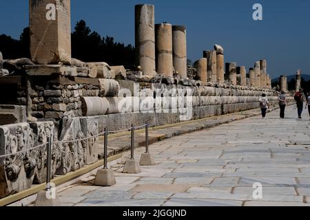 I turisti camminano lungo una strada nella città un tempo grande di Efeso in Turchia Foto Stock