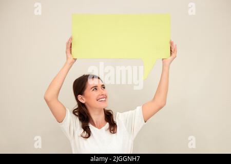 Parla ciò che ti sta a cuore, una giovane donna che tiene un cartello su sfondo bianco. Foto Stock