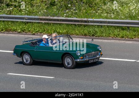 1965 60s verde MG B MGB 1789cc benzina cabriolet. Auto sportiva britannica che guida sull'autostrada M6, Regno Unito Foto Stock