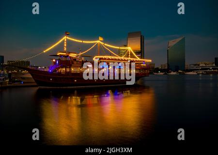 Dubai, Emirati Arabi Uniti, 13 novembre 2020: Vista del Dubai Creek nella vecchia Dubai nella zona di al Seef. Crociera in sambuco splendidamente illuminata ormeggiata con un riflesso stupefacente. Foto Stock