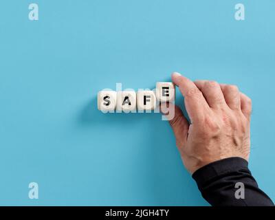 Maschio mano che dispone i cubi di legno con la parola cassaforte. Concetto di sicurezza e protezione. Foto Stock