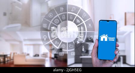 Man Hand show smartphone smart home GUI controlla ogni stanza della casa. Utilizzare l'assistente di automazione domestica intelligente con schermo intelligente su uno schermo virtuale e un Foto Stock