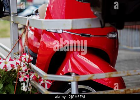 scooter rosso in città. Ciclomotore retrò Foto Stock