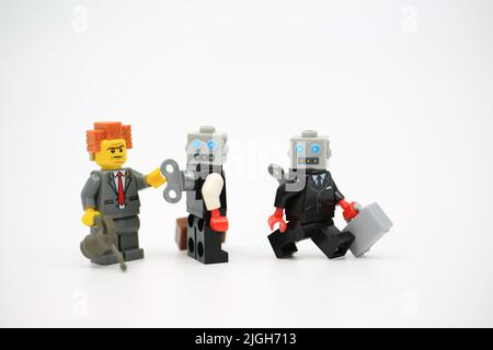 L'uomo aiuta a riavvolgere il robot di orologio Foto Stock