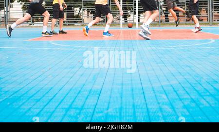 gli uomini che giocano a basket all'aperto non ritagliano spazio copia volti Foto Stock