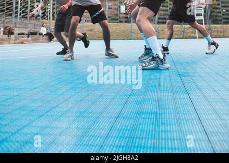 gli uomini che giocano a basket all'aperto non ritagliano spazio copia volti Foto Stock