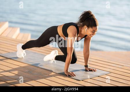 Atletica donna nera formazione all'aperto, vista laterale Foto Stock