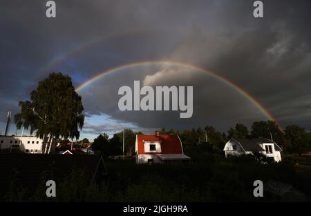 Motala, Svezia. 10th, luglio 2022. Doppio arcobaleno sulla città di Motala , Svezia, durante la domenica sera. Un arcobaleno è un fenomeno meteorologico causato dalla riflessione, dalla rifrazione e dalla dispersione della luce nelle goccioline d'acqua, con conseguente comparsa di uno spettro di luce nel cielo. Credit: Jeppe Gustafsson/Alamy Live News Foto Stock