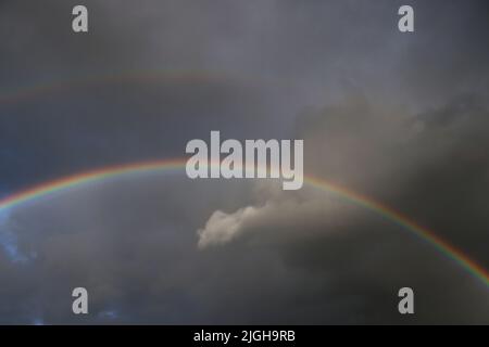 Motala, Svezia. 10th, luglio 2022. Doppio arcobaleno sulla città di Motala , Svezia, durante la domenica sera. Un arcobaleno è un fenomeno meteorologico causato dalla riflessione, dalla rifrazione e dalla dispersione della luce nelle goccioline d'acqua, con conseguente comparsa di uno spettro di luce nel cielo. Credit: Jeppe Gustafsson/Alamy Live News Foto Stock