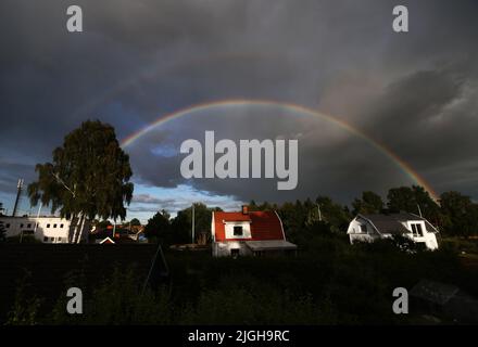 Motala, Svezia. 10th, luglio 2022. Doppio arcobaleno sulla città di Motala , Svezia, durante la domenica sera. Un arcobaleno è un fenomeno meteorologico causato dalla riflessione, dalla rifrazione e dalla dispersione della luce nelle goccioline d'acqua, con conseguente comparsa di uno spettro di luce nel cielo. Credit: Jeppe Gustafsson/Alamy Live News Foto Stock