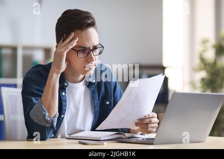 Ritratto dei documenti di lettura dei dipendenti maschili focalizzati sul luogo di lavoro in ufficio Foto Stock