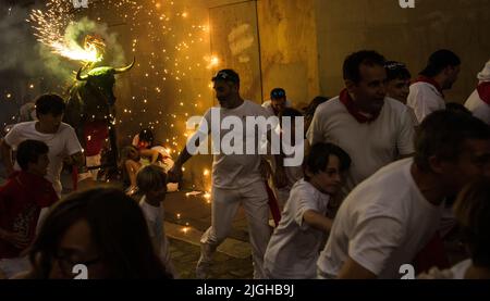 Pamplona, Spagna, 10 luglio 2022 . La gente e i bambini sono inseguiti dalla 'Toro de Fuego' (toro fiammeggiante) mentre corre per le strade durante la corsa di San Fermin della fiesta dei tori. Credit: Mikel Cia da Riva/Alamy Live News Foto Stock