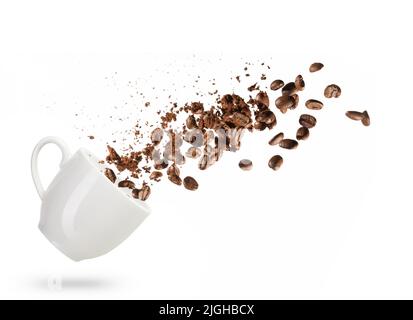 i chicchi di caffè fuoriescono da una tazza isolata su sfondo bianco Foto Stock