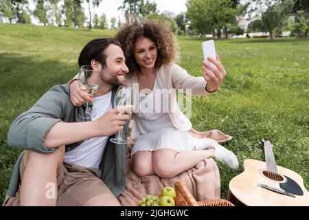 felice giovane coppia prendere selfie su smartphone durante estate pic-nic nel parco Foto Stock