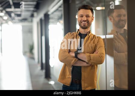 Un uomo d'affari di successo che si pone in piedi nella porta di Office Foto Stock