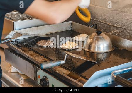 Cucina polpettine di carne per hamburger in Street cafe Foto Stock