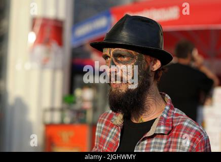 Ritratto di un giovane uomo barbuto in un cappello, volto artistico tatuaggio. Maggio 19, 2019. Kiev, Ucraina Foto Stock