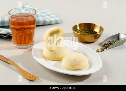 Bakpia Kukus Putih. Bakpia al vapore bianco. I souvenir di Yogya sono come torte al vapore riempite con vari ripieni. Servito con tè Foto Stock