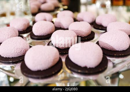 Dessert freschi, appetitosi, dolci e moderni si avvicinano a un tavolo a buffet decorato Foto Stock