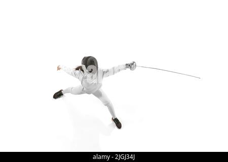 Ragazza giovane, fencer principiante in costume da scherma e maschera pratica con pinza isolato su sfondo bianco. Sport, gioventù, stile di vita sano Foto Stock