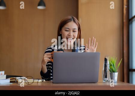 Videochiamata, incontro d'affari online, briefing. Il freelance caucasico di successo agitava la mano e salutava i colleghi durante la videoconferenza. Distante Foto Stock