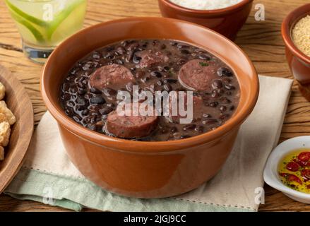 Tipica feijoada brasiliana con riso, caipirinha, farofa e cracklings. Foto Stock