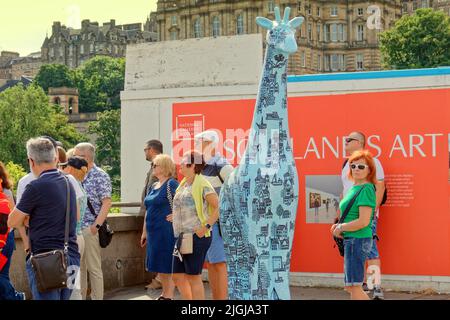 Edimburgo, Scozia, Regno Unito luglio 11th 2022. Tempo UK: Soleggiato come locali e turisti ha preso ai giardini di strada dei principi e strade locali per godersi il sole come un certo numero di statue giraffe ispirate all'arte sono trovati adornando il Pavements.Edinburgh Zoo, in collaborazione con produttori creativi Wild in Art, Presentare Giraffe About Town – il nostro grande evento di arte pubblica a Edimburgo quest'estate. . Credit Gerard Ferry/Alamy Live News Foto Stock