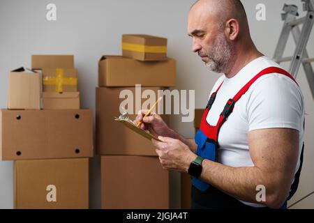 L'uomo di mezza età si mover in uniforme facendo note sugli appunti Foto Stock