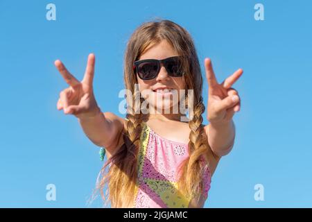 Ragazza felice in occhiali con le mani sollevate contro il cielo. Foto Stock