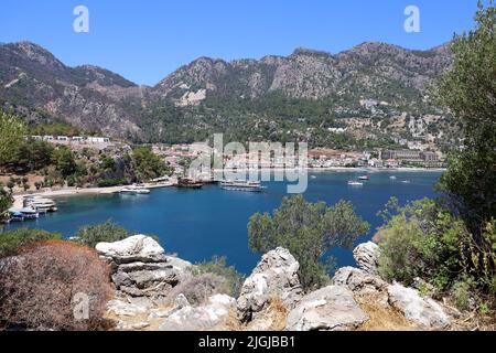 Vista sulla baia blu e yacht turistici circondati da montagne verdi. Turunc città, resort estivo in mare Mediterraneo sulla costa della Turchia Foto Stock