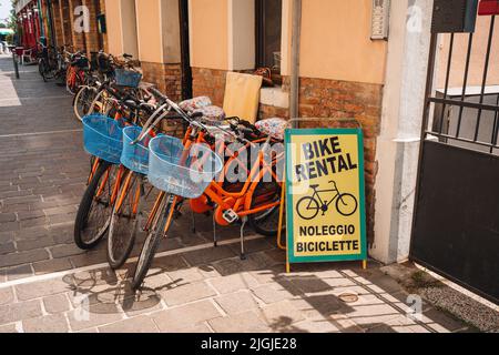 Venezia, Italia - 22 maggio 2022: Noleggio biciclette parcheggiate sul cartello del negozio di noleggio sull'isola di Lido, un'isola barriera della Laguna Veneta famosa per il suo Film Festival Foto Stock