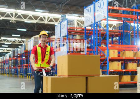 Scatole di spedizione. Asian MAN Warehouse Worker scarico pallet spedizione merci in un container camion, magazzino industria merci, logistica e trasporto Foto Stock