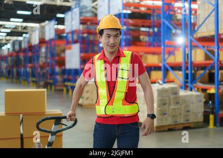 Scatole di spedizione. Asian MAN Warehouse Worker scarico pallet spedizione merci in un container camion, magazzino industria merci, logistica e trasporto Foto Stock