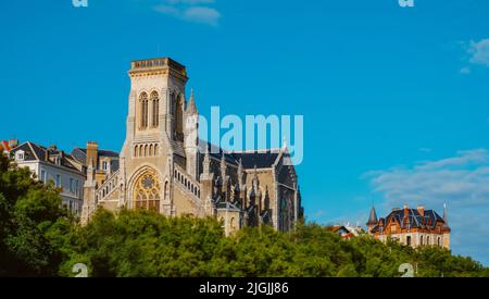 Una vista della parte superiore della Chiesa Sainte-Eugenie a Biarritz, Francia, che sovrasta le cime degli alberi Foto Stock