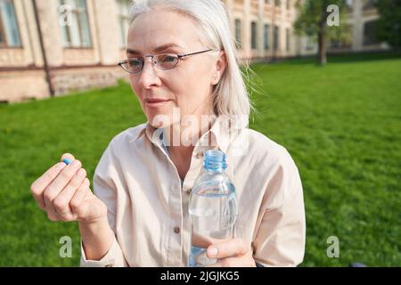 Gentile donna matura che sta andando prendere la medicina Foto Stock