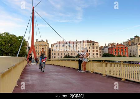 Persone che attraversano Passerelle du Palais de Justice Bridge sul fiume Saone guardando verso il centro di Lione, Francia Foto Stock