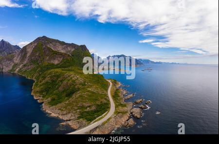 Strada per Reine villaggio circondato da alte montagne e il mare sulle isole Lofoten Foto Stock