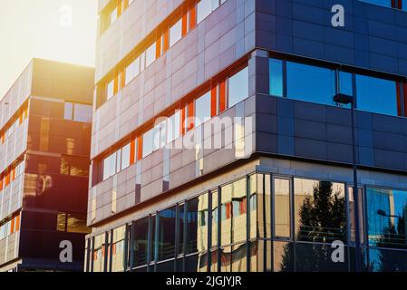 Facciata di edificio al tramonto, moderno edificio di uffici in città per le imprese d'affari, residenziale contemporaneo Foto Stock