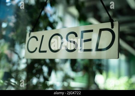 Imbarco con avviso informativo sulla porta d'ingresso del ristorante che dice chiuso. Foto Stock