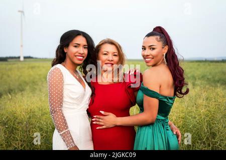 ritratto di tre donne ispaniche che abbraccia all'aperto in natura Foto Stock