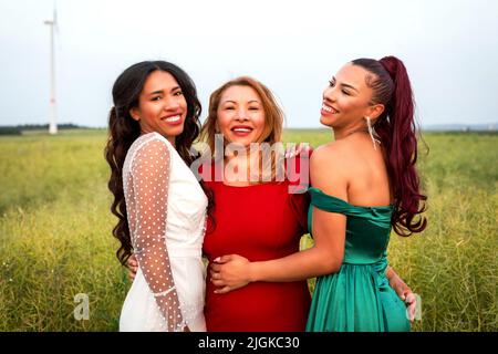 ritratto di tre donne ispaniche che abbraccia all'aperto in natura Foto Stock