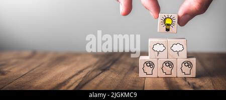Blocchi di legno sul tavolo con simbolo della squadra e della lampadina - successo attraverso il concetto di lavoro di squadra Foto Stock