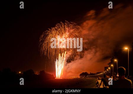 Festa dei fuochi d'artificio al lago Bundek, sulla riva del fiume Sava di notte, raccogliendo una grande folla di persone che guardano esplosioni colorate Foto Stock