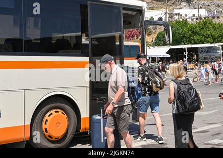 Lindos, Rodi, Grecia - Maggio 2022: Persone che pesano un autobus pubblico alla fermata del bus della città Foto Stock