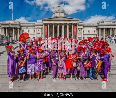 I Red Hatters si incontrano e posano per una fotografia presso la National Gallery. La Red Hat Society è un club sociale mondiale per le donne. Foto Stock