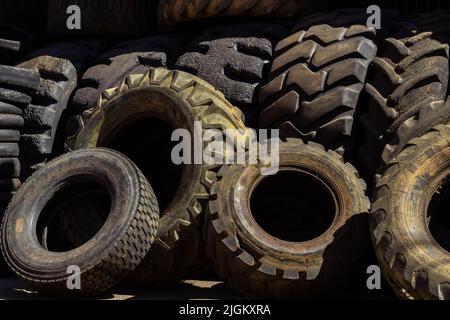 Goiânia, Goiás, Brasile – 10 luglio 2022: Molti pneumatici vecchi e sporchi di diverse dimensioni si sono impigliati in un negozio specializzato. Pneumatici in gomma, usati. Foto Stock
