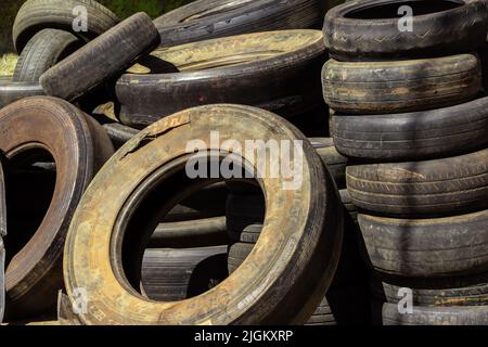 Goiânia, Goiás, Brasile – 10 luglio 2022: Molti pneumatici vecchi e sporchi di diverse dimensioni si sono impigliati in un negozio specializzato. Pneumatici in gomma, usati. Foto Stock