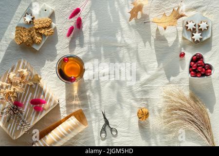 Fiori di crisantemo arancio, erba secca di coda conigliata e foglie di quercia rossa, zucche, mirtillo. Decorazioni autunnali, vista dall'alto Foto Stock